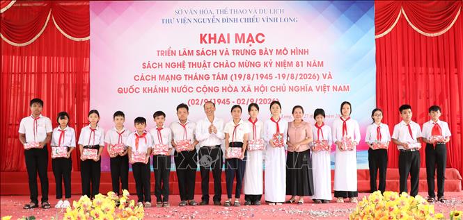 Ban Tổ chức trao quà cho học sinh vượt khó học giỏi tại lễ khai mạc triển lãm. Ảnh: Thanh Hòa - TTXVN