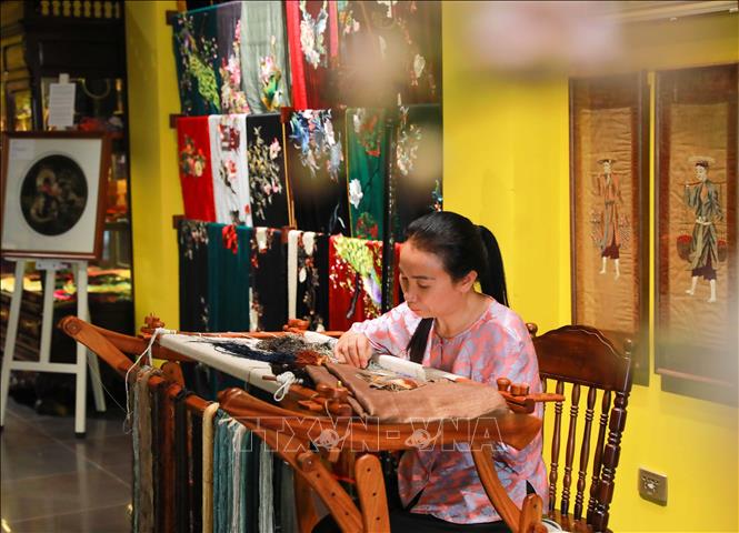 Nghệ nhân làng thêu Quất Động trực tiếp làm việc trong không gian nghệ thuật. Ảnh: Khánh Hoà - TTXVN