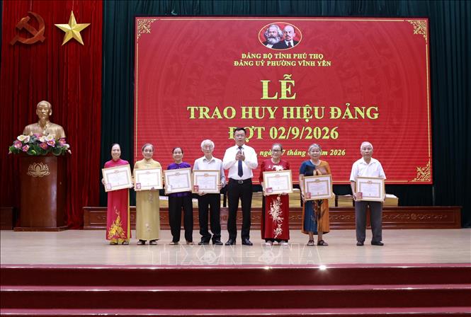 Các đảng viên nhận Huy hiệu 60 năm và 65 năm tuổi Đảng. Ảnh: Hoàng Hùng - TTXVN