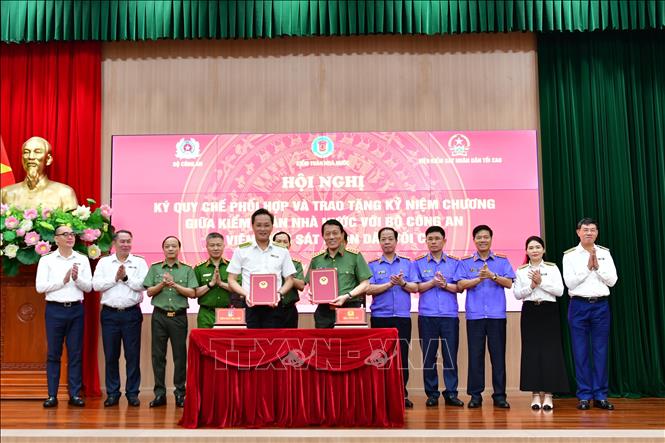 Bộ trưởng Bộ Công an Lương Tam Quang và Tổng Kiểm toán Nhà nước Nguyễn Hữu Nghĩa trao Quy chế phối hợp công tác. Ảnh: TTXVN phát