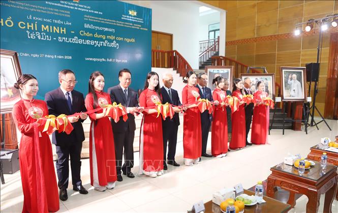 Các đại biểu hai nước cắt băng khai mạc Triển lãm “Hồ Chí Minh - Chân dung một con người”. Ảnh: Xuân Tú - PV TTXVN tại Lào