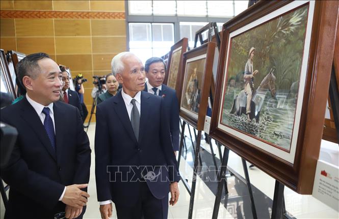 Đồng chí Khamphan Pheuiyavong, Ủy viên Bộ Chính trị, Trưởng ban Tuyên huấn Trung ương Lào và đại biểu tham quan triển lãm. Ảnh: Xuân Tú - PV TTXVN tại Lào