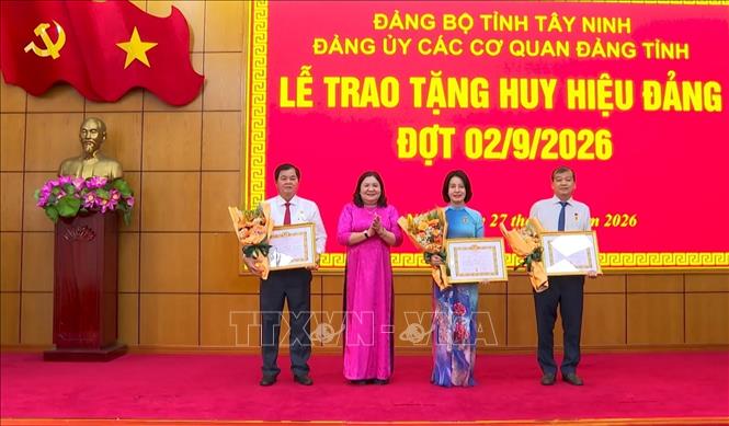 Ủy viên BCH Trung ương Đảng, Phó Bí thư Thường trực Tỉnh ủy Tây Ninh Hồ Thị Hoàng Yến trao Huy hiệu Đảng cho các đảng viên. Ảnh: Thanh Bình –TTXVN