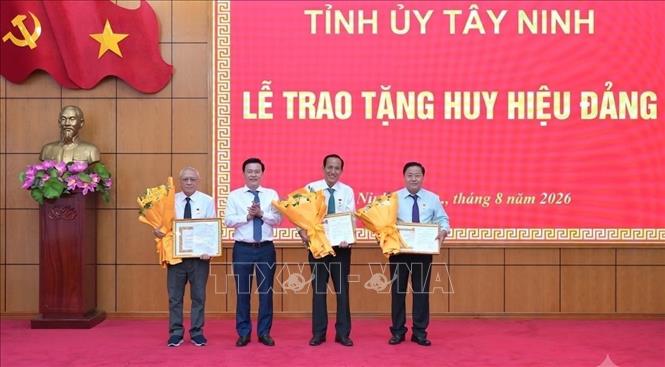 Phó Bí thư Tỉnh ủy, Chủ tịch Ủy ban Mặt trận Tổ quốc Việt Nam tỉnh Tây Ninh Nguyễn Thanh Hải  trao Huy hiệu Đảng cho các đảng viên. Ảnh: Thanh Bình- TTXVN