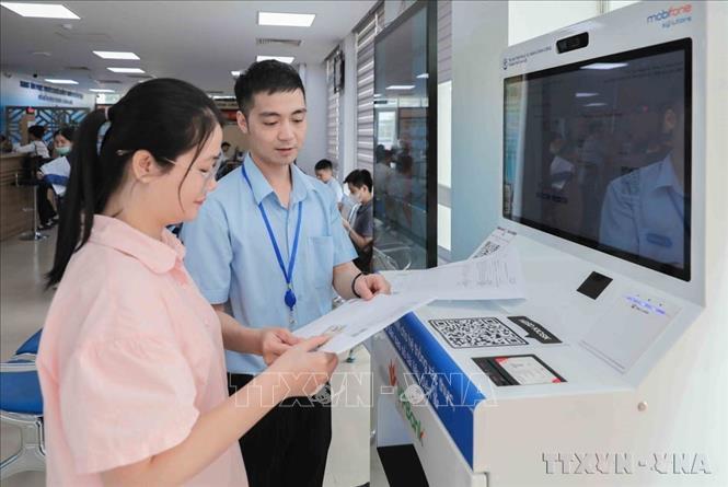 Kết luận 76-KL/TW nhấn mạnh tiếp tục hoàn thiện, vận hành hiệu quả mô hình tổ chức tổng thể của hệ thống chính trị và mô hình chính quyền địa phương 2 cấp. Trong ảnh: Cán bộ Chi nhánh số 6 Trung tâm Phục vụ hành chính công Hà Nội tại xã Gia Lâm hướng dẫn người dân dùng Ki ốt AI cấp bản sao số điện tử miễn phí, dùng trọn đời. Ảnh: Phan Phương – TTXVN