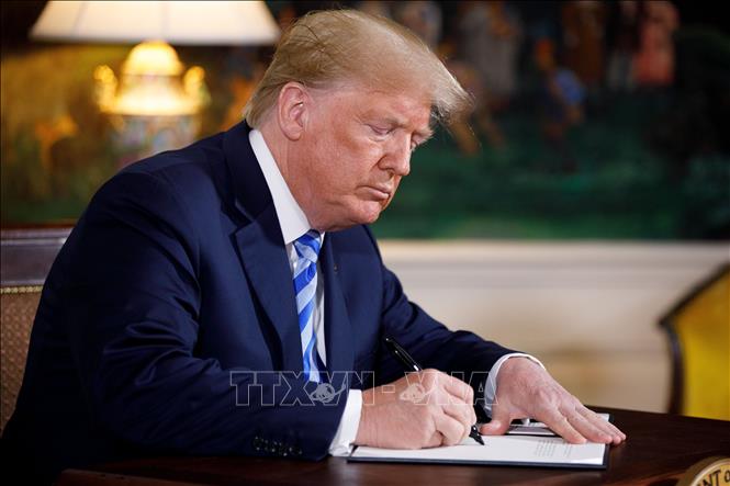 (Tư liệu) Tổng thống Mỹ Donald Trump ký sắc lệnh tại Nhà Trắng. Ảnh: THX/TTXVN phát