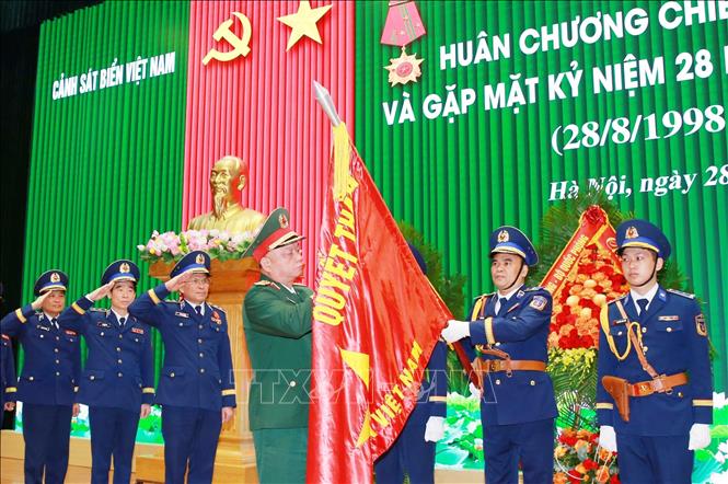 Thượng tướng Nguyễn Quang Ngọc, Ủy viên Trung ương Đảng, Thứ trưởng Bộ Quốc phòng gắn Huân chương Chiến công hạng Nhất lên Quân kỳ Quyết thắng của Cảnh sát biển Việt Nam. Ảnh: Trọng Đức - TTXVN