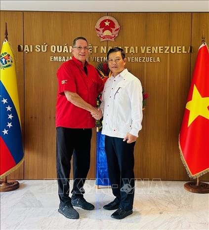 Phó Chủ tịch PSUV Jesús Faría (trái) chụp ảnh chung với Đại sứ Việt Nam tại Venezuela Vũ Trung Mỹ. Ảnh: TTXVN phát