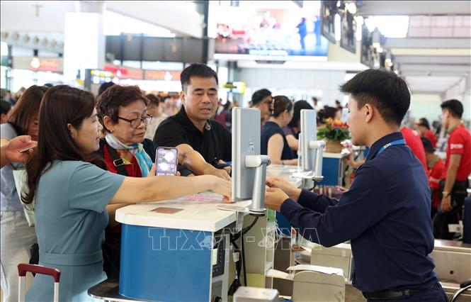 Hành khách làm thủ tục tại quầy của Hãng hàng không Phú Quốc Air trong buổi sáng 28/8. Ảnh: Quốc Khánh - TTXVN