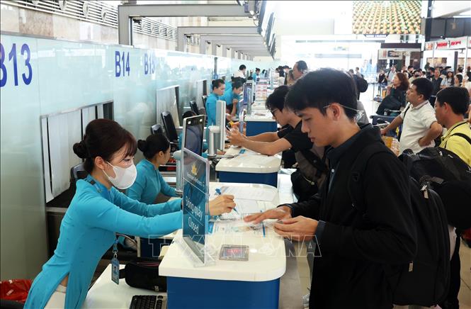 Hành khách làm thủ tục check-in tại quầy của Vietnam Airlines, sáng 28/8. Ảnh: Quốc Khánh - TTXVN