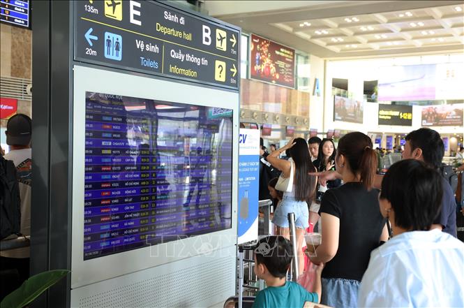 Hành khách tìm kiếm thông tin chuyến bay trên bảng thông báo tại sân bay Nội Bài, sáng 28/8. Ảnh: Quốc Khánh - TTXVN