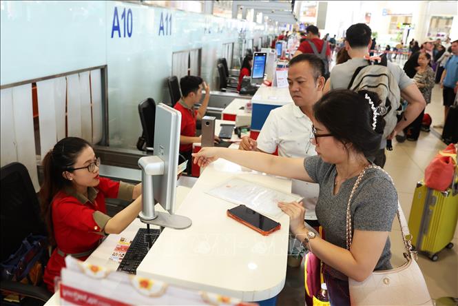 Hành khách làm thủ tục tại quầy của Hãng hàng không VietJet Air, sáng 28/8. Ảnh: Quốc Khánh - TTXVN