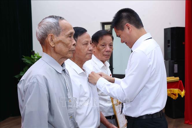 Đồng chí Nguyễn Văn Bằng, Phó Bí thư Đảng ủy, Chủ tịch UBND xã Phúc Thịnh (Hà Nội) trao Huy hiệu 55 năm tuổi Đảng cho các đảng viên. Ảnh: Văn Điệp - TTXVN