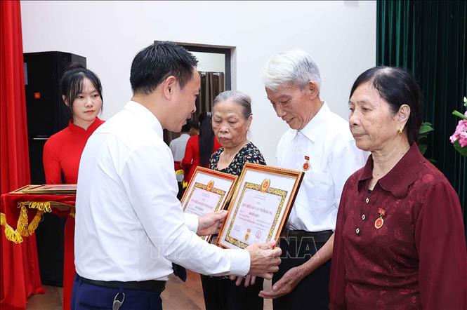 Đồng chí Đặng Minh Thắng, Phó Bí thư Thường trực Đảng ủy xã Phúc Thịnh (Hà Nội) trao Huy hiệu 60 năm tuổi Đảng cho các đảng viên. Ảnh: Văn Điệp – TTXVN
