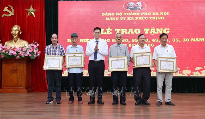Đồng chí Nguyễn Văn Bằng, Phó Bí thư Đảng ủy, Chủ tịch UBND xã Phúc Thịnh (Hà Nội) trao Huy hiệu 55 năm tuổi Đảng cho các đảng viên. Ảnh: Văn Điệp - TTXVN