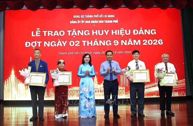 Trao Huy hiệu 45 năm tuổi Đảng cho các đảng viên. Ảnh: Liên Sơn - TTXVN 
