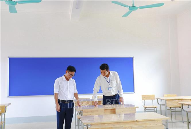 Lãnh đạo UBND xã Sam Mứn và nhà trường kiểm tra các thiết bị trong phòng học trước ngày khai giảng năm học mới. Ảnh: Xuân Tư - TTXVN