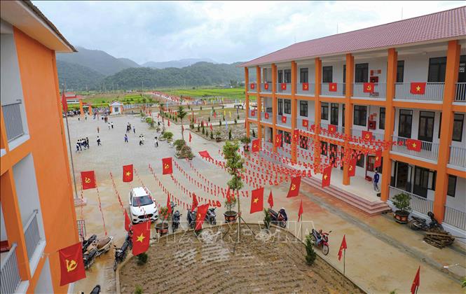 Cờ Đảng, cờ Tổ quốc được trang trí dọc các dãy nhà, tạo sắc màu nổi bật trong khuôn viên Trường Phổ thông nội trú Tiểu học và THCS Sam Mứn. Ảnh: Xuân Tư - TTXVN