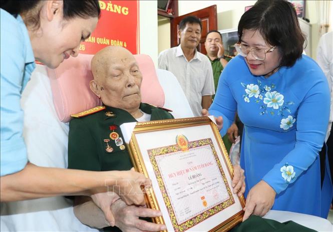 Đồng chí Văn Thị Bạch Tuyết, Phó Bí thư Thành ủy TP. Hồ Chí Minh trao Huy hiệu 80 năm tuổi Đảng cho đồng chí Lê Hoằng, cán bộ tiền khởi nghĩa, nguyên Phó Bí thư Đảng ủy Cục Hậu cần Quân đoàn, nguyên Cục trưởng Cục hậu cần Quân đoàn 4. Ảnh: TTXVN phát