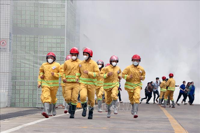 Công nhân lao động và Lực lượng PCCC tại chỗ triển khai các biện pháp chữa cháy ban đầu. Ảnh: Thanh Vũ - TTXVN
