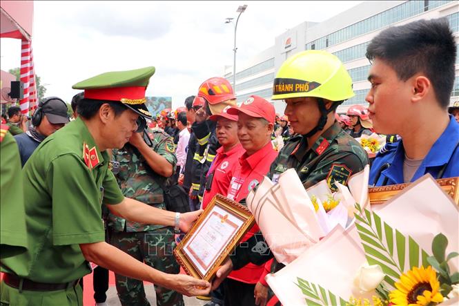 Thiếu tướng Nguyễn Thanh Hưởng, Phó Giám đốc Công an TP. Hồ Chí Minh tặng hoa chúc mừng các lực lượng tham gia diễn tập chữa cháy và cứu nạn, cứu hộ tại Công ty TNHH Timberland. Ảnh: Thanh Vũ - TTXVN