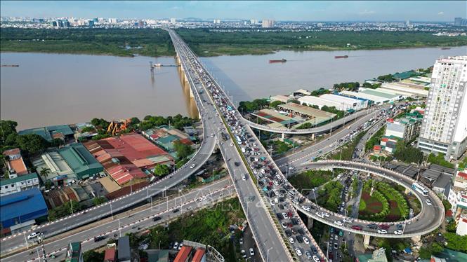 Các dòng xe ô tô, xe máy nối đuôi nhau di chuyển chậm trên cầu Vĩnh Tuy.  Ảnh: Minh Quyết - TTXVN