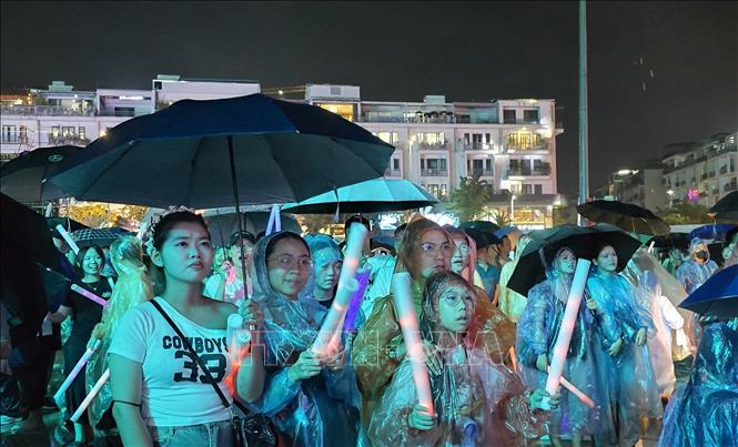 Nhân dân và du khách đội mưa thưởng thức “Quảng Ninh - Thành phố rạng rỡ tương lai”. Ảnh: Thanh Vân- TTXVN