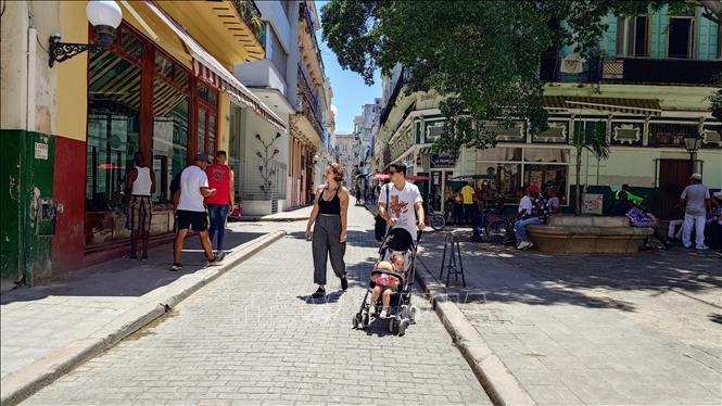 Du khách đi bộ dưới trời nắng nóng tại khu vực phố cổ thủ đô La Habana, Cuba. Ảnh: Phi Hùng - PV TTXVN tại Mỹ Latinh 