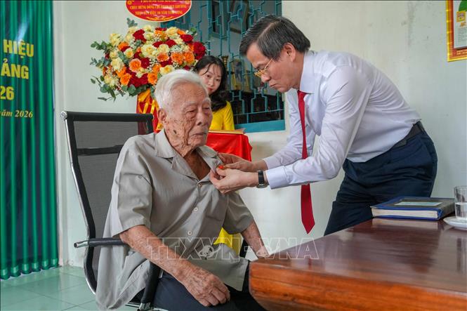 Ông Đoàn Minh Huấn, Ủy viên Bộ Chính trị, Giám đốc Học viện Chính trị Quốc gia Hồ Chí Minh trao Huy hiệu 80 năm tuổi Đảng cho đảng viên Phạm Duy Khương. Ảnh: Thanh Liêm - TTXVN