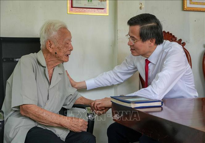 Ông Đoàn Minh Huấn, Ủy viên Bộ Chính trị, Giám đốc Học viện Chính trị Quốc gia Hồ Chí Minh thăm hỏi đảng viên Phạm Duy Khương. Ảnh: Thanh Liêm - TTXVN