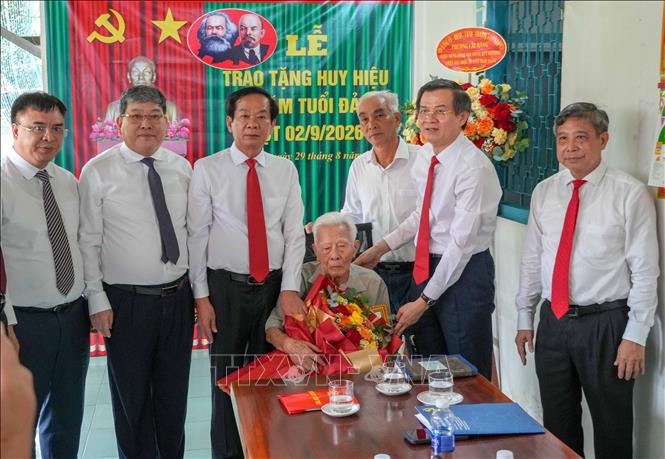Ông Đoàn Minh Huấn, Ủy viên Bộ Chính trị, Giám đốc Học viện Chính trị Quốc gia Hồ Chí Minh trao Huy hiệu 80 năm tuổi Đảng cho đảng viên Phạm Duy Khương. Ảnh: Thanh Liêm - TTXVN