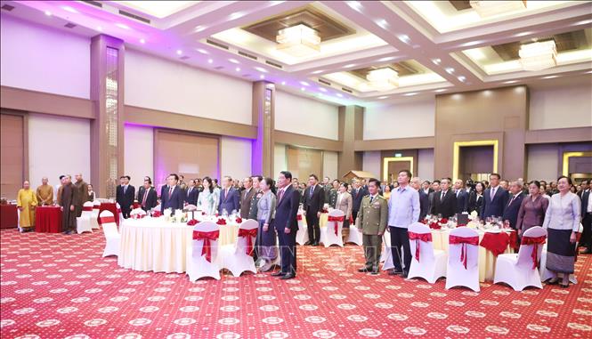 Các đại biểu tham dự Tiệc chiêu đãi thực hiện nghi lễ Chào cờ. Ảnh: Xuân Tú - PV TTXVN tại Lào