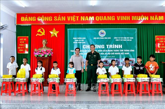 Đại diện Ban chỉ huy Bộ đội Biên phòng thành phố Cần Thơ và nhà hảo tâm trao quà cho học sinh có hoàn cảnh khó khăn. Ảnh: Trung Kiên - TTXVN