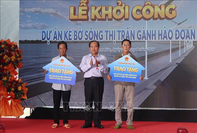 Phó Chủ tịch UBND tỉnh Cà Mau Nguyễn Minh Luân trao tặng bảng tượng trưng 2 căn nhà cho hộ dân. Ảnh: Tuấn Phi - TTXVN