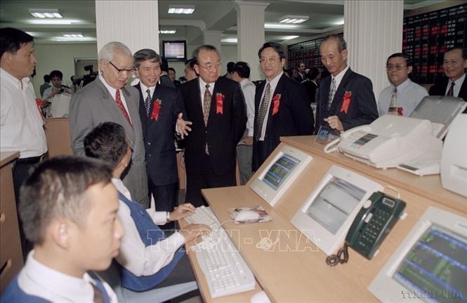 Thực hiện công cuộc đổi mới toàn diện, trong đó trọng tâm là đổi mới kinh tế là quyết định lịch sử, tạo bước ngoặt ấn tượng trong chặng đường phát triển kinh tế của đất nước. Trong ảnh: Cố vấn Võ Văn Kiệt cùng các đại biểu thăm sàn giao dịch Chứng khoán thành phố Hồ Chí Minh trong ngày khai trương Trung tâm (20/7/2000). Ảnh: Tứ Hải - TTXVN