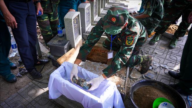 Cán bộ, chiến sĩ Đội K71 cẩn trọng ấy mẫu sinh phẩm hài cốt liệt sĩ tại Nghĩa trang liệt sỹ Dương Minh Châu, Tây Ninh. Ảnh: Minh Phú - TTXVN 