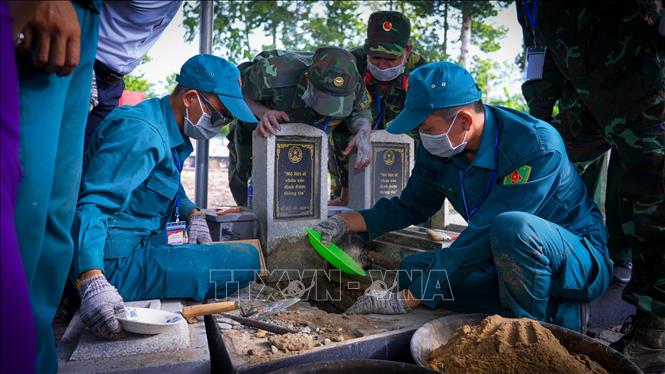 Các lực lượng phối hợp thực hiện khai quật, lấy mẫu và thu thập thông tin phục vụ xác định danh tính liệt sĩ. Ảnh: Minh Phú - TTXVN 