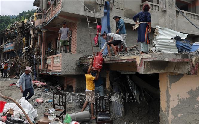 Người dân thu dọn đồ đạc sau lũ quét tại Nuwakot, Nepal. Ảnh: ANI/TTXVN phát