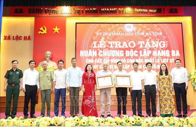 Các đại biểu tỉnh và địa phương chụp ảnh lưu niệm cùng thân nhân các gia đình được trao tặng Huân chương. Ảnh: Hữu Quyết - TTXVN