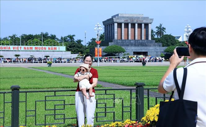 Một em bé được gia đình đưa đi chơi trong ngày nghỉ lễ. Ảnh: Tuấn Anh - TTXVN