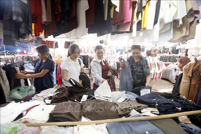 Khách chọn mua quần áo tại hội chợ. Ảnh: Quang Quyết - TTXVN