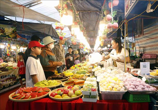 Khách chọn mua các sản phẩm bánh, kẹo dẻo tại hội chợ. Ảnh: Quang Quyết - TTXVN