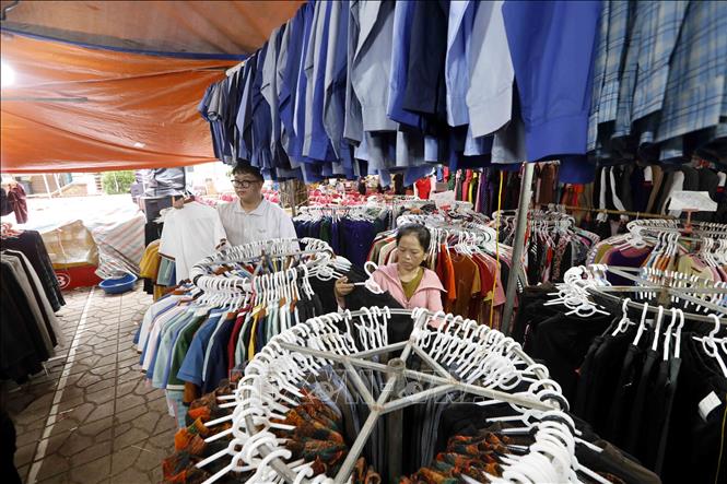 Khách chọn mua quần áo tại hội chợ. Ảnh: Quang Quyết - TTXVN