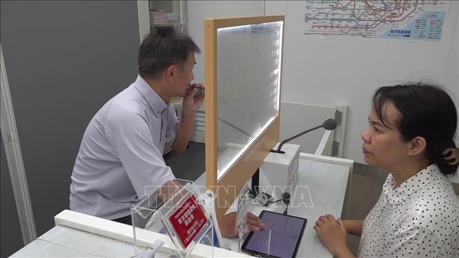 Nhân viên nhà ga đang trả lời câu hỏi của phóng viên hiển thị trên màn hình phiên dịch. Ảnh: Xuân Giao - Pv TTXVN tại Nhật Bản