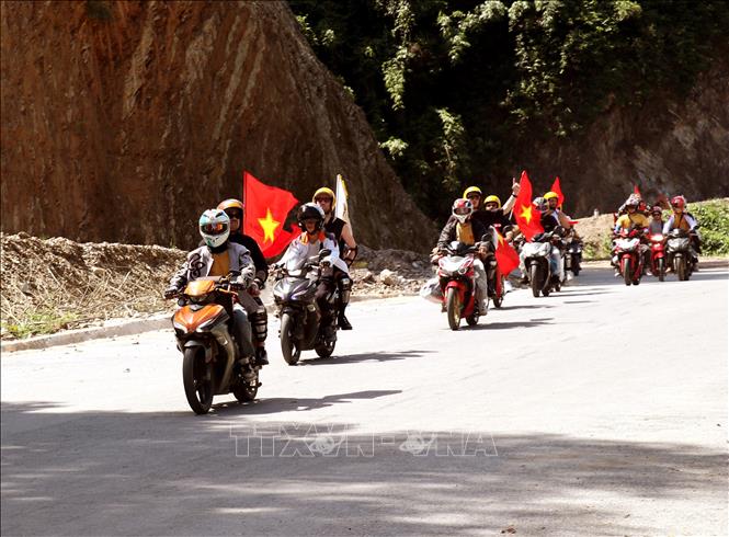 Lá cờ đỏ sao vàng tung bay xuyên suốt chuyến hành trình khám phá vùng Cao nguyên đá Đồng Văn. Ảnh: Đức Thọ - TTXVN.