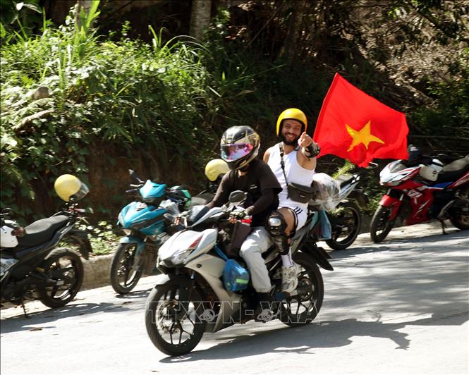 Lá cờ đỏ sao vàng tung bay xuyên suốt chuyến hành trình khám phá vùng Cao nguyên đá Đồng Văn. Ảnh: Đức Thọ - TTXVN.