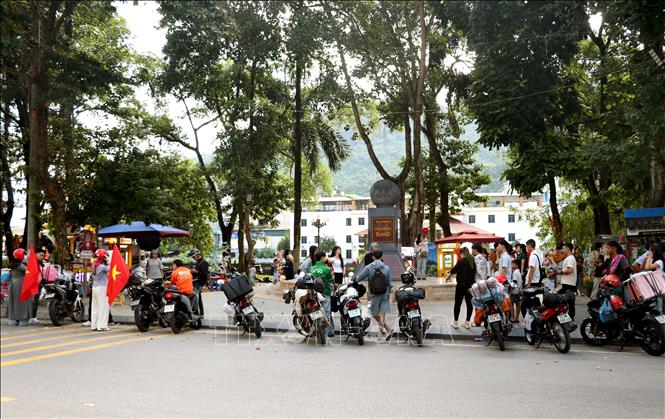 Khách du lịch khám phá, chụp ảnh lưu niệm tại Km0 Hà Giang. Ảnh: Đức Thọ - TTXVN.