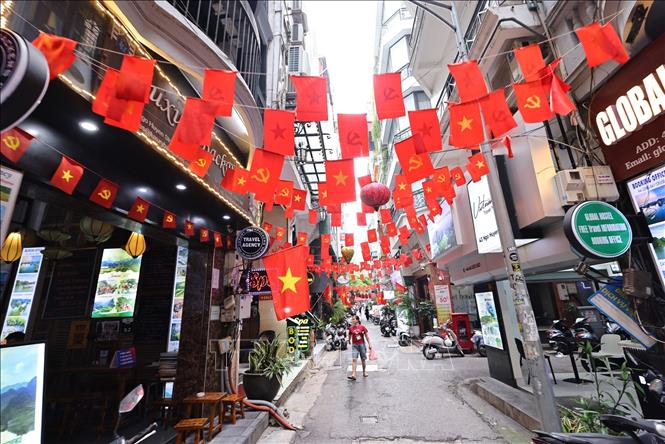 Cờ Tổ quốc và cờ Đảng trang hoàng rực rỡ ở Ngõ Huyện, phường Hoàn Kiếm. Ảnh: Minh Đức – TTXVN