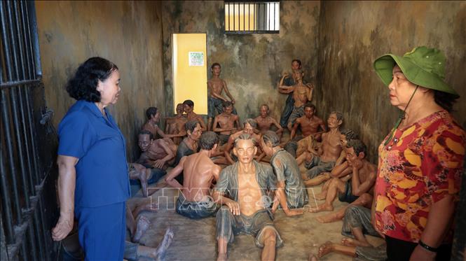 Anh hùng lực lượng vũ trang nhân dân Võ Thị Hóa (áo xanh) và bà Phạm Thị Thu, những người từng bị giam cầm tại Nhà lao Hội An, tham quan một phòng giam đã được tái hiện bối cảnh lịch sử năm xưa. Ảnh: Đỗ Trưởng – TTXVN