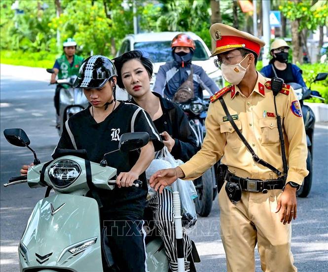 Lực lượng Cảnh sát giao thông hướng dẫn người điều khiển xe máy vào vị trí kiểm tra. Ảnh: Trung Nguyên - TTXVN